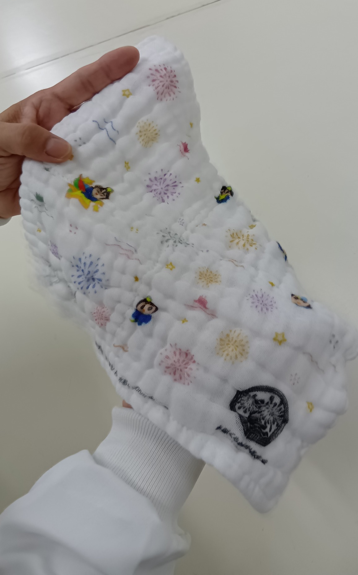 手で広げたひこぼしくんガーゼハンカチの自然なたわみと厚み
